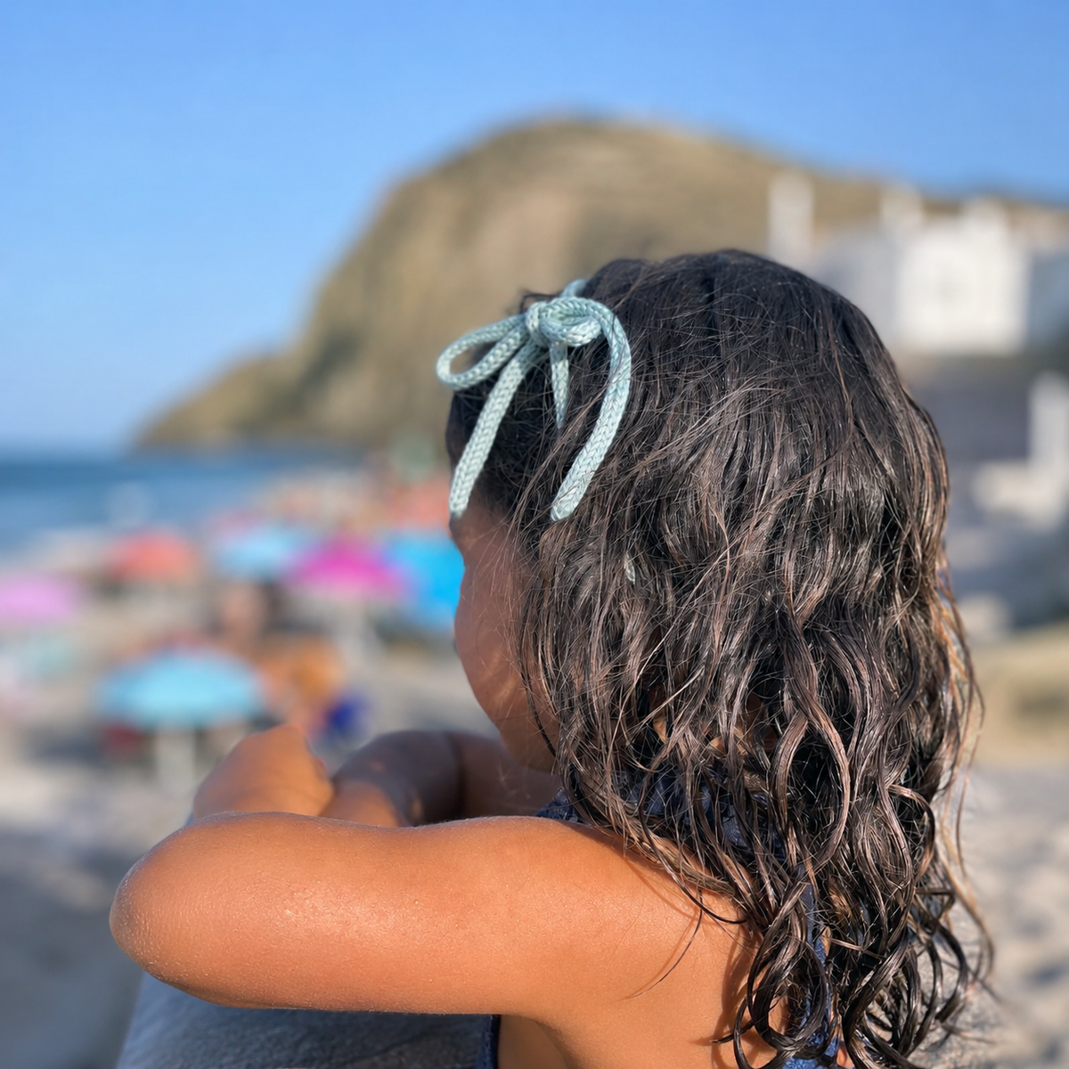 Diadema de crochet con lazo verde en peinado infantil boho