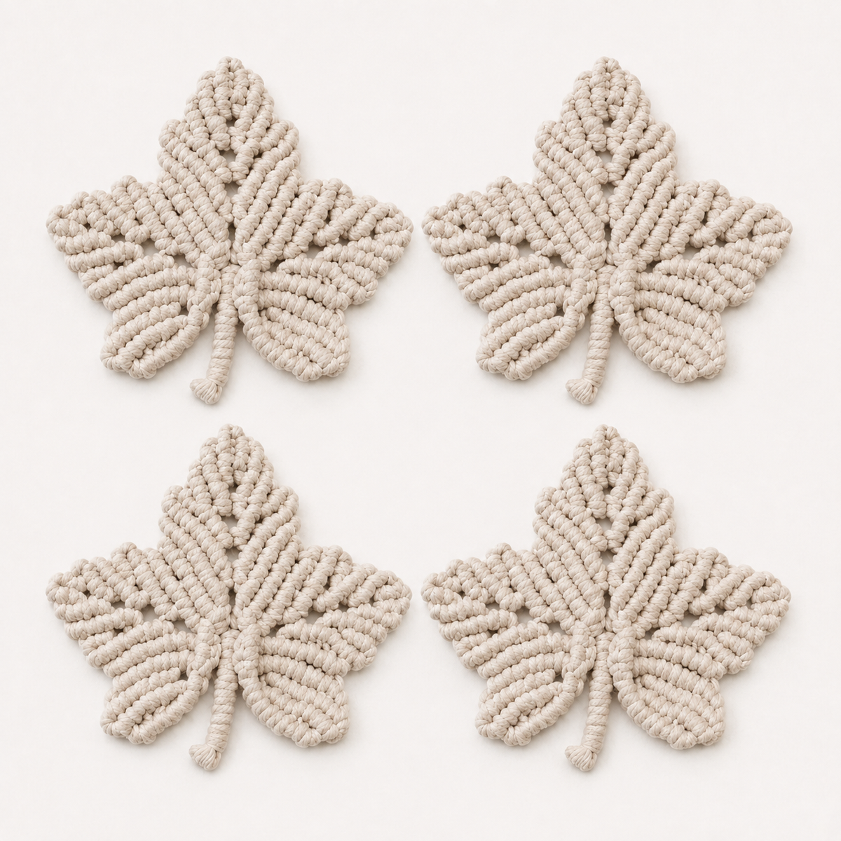 Pack de 4 posavasos hoja de arce de macramé color lino sobre fondo blanco, diseño artesanal decorativo.